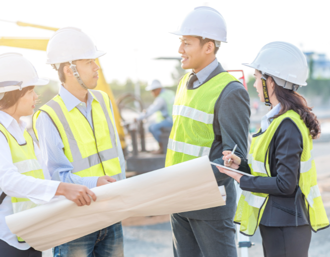 group of workers onsite holding paper